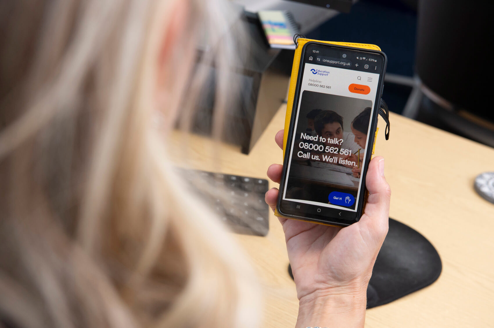 Teacher viewing content on a mobile phone in an office 