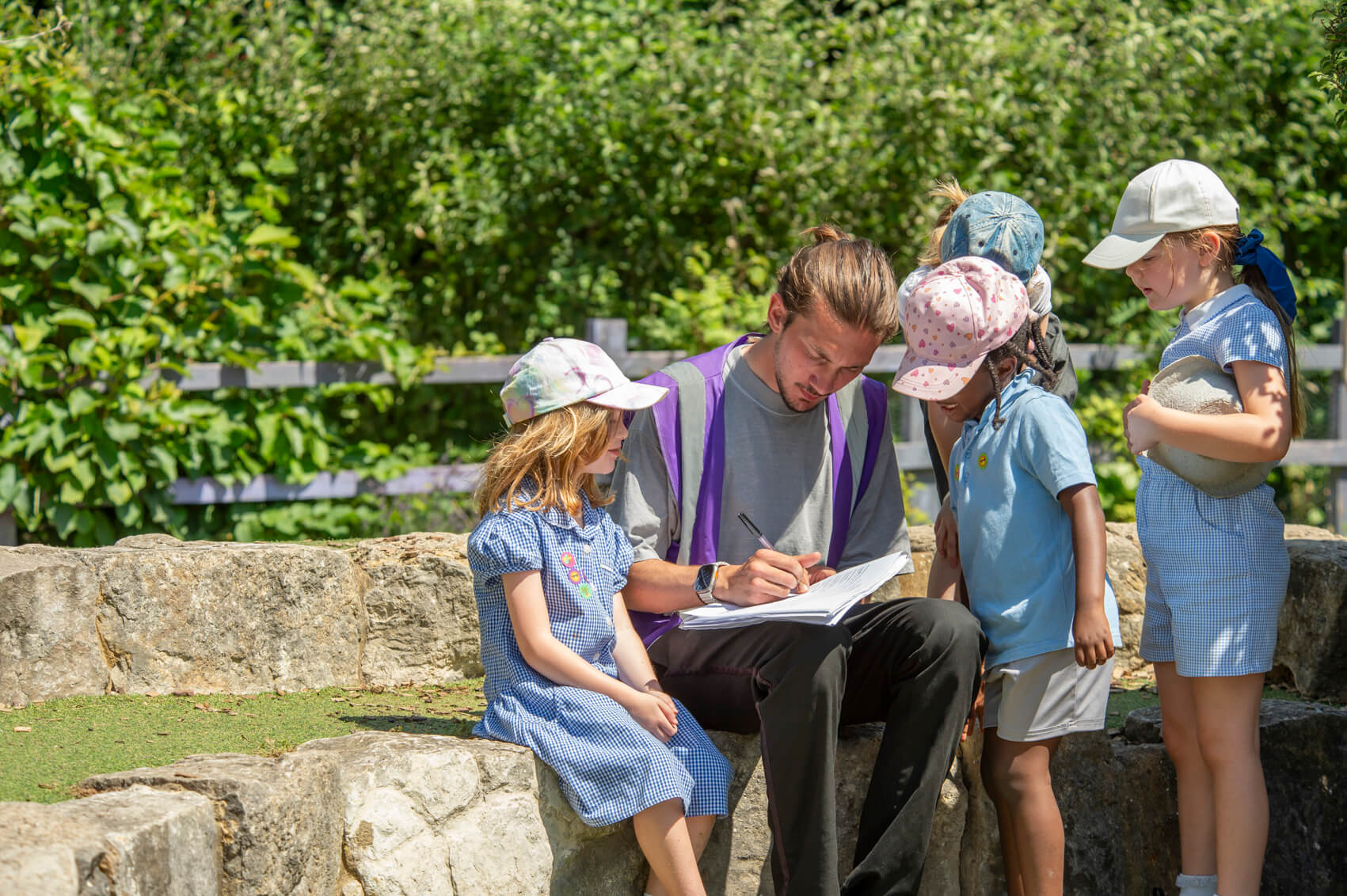 A lunchtime supervisor chatting to pupils in the playground 